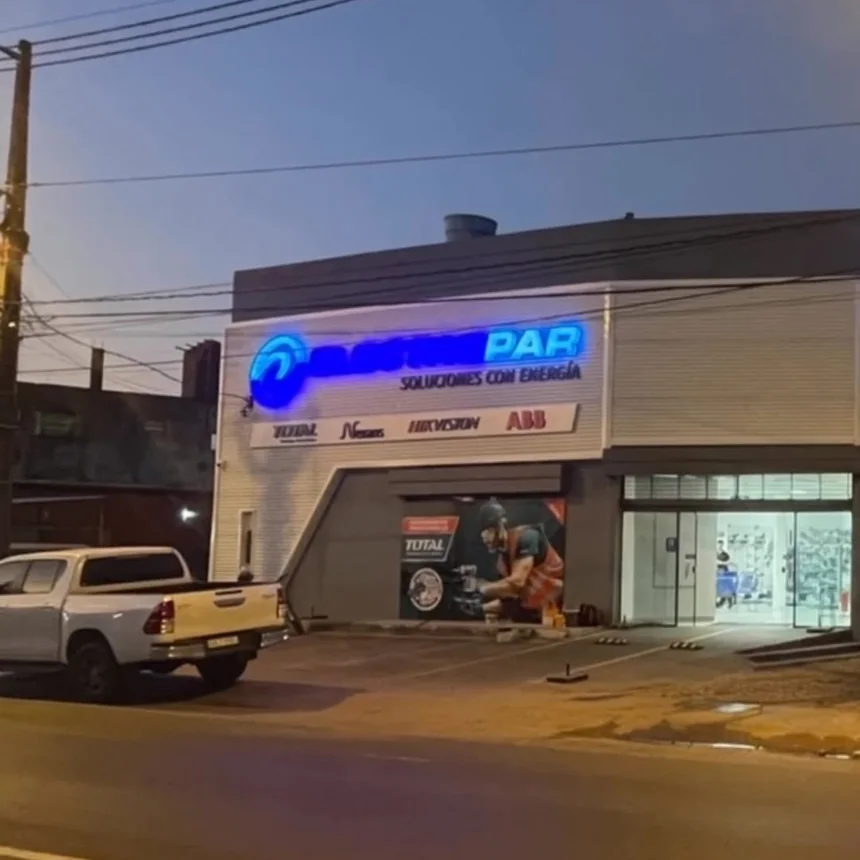 Local de Electropar con el letrero iluminado al atardecer